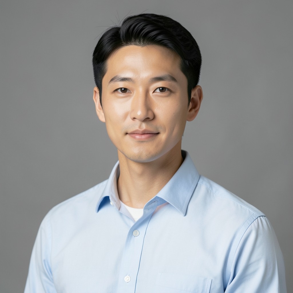 Portrait of a man in a light blue shirt against a plain gray background